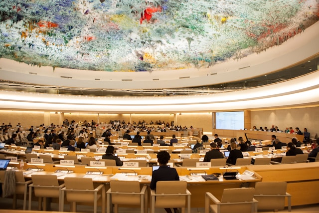 sala pełna ludzi siedzących, słuchających prelekcji